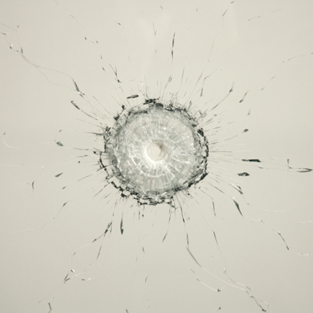 オノ・ヨーコ《穴》2009 年、弾の貫通した板ガラス、刻印されたテキスト「ガラスの反対側に廻り、穴から覗く」、金属の枠（部分）、個人蔵