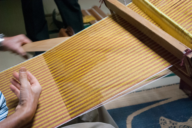 工房では、幾つもの織機で黄八丈が織られていく